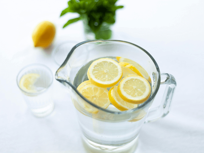 full pitcher of water with lemon slices